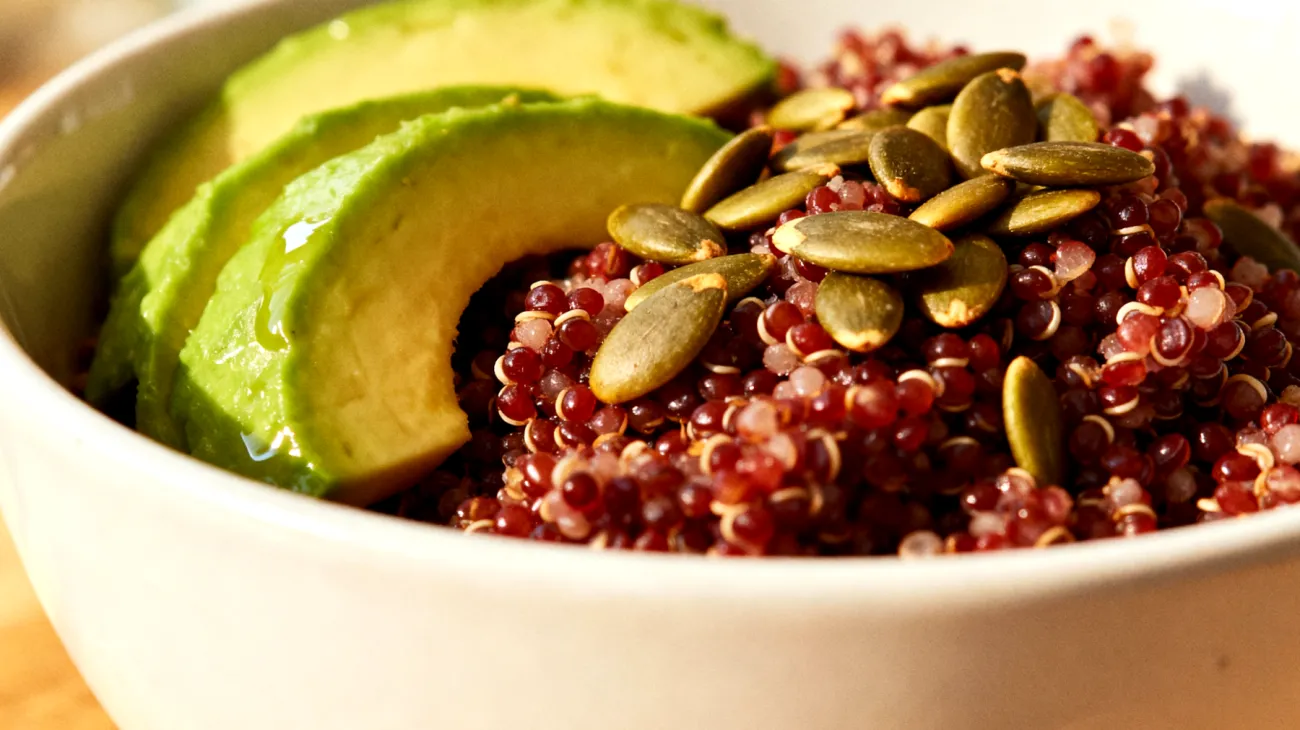 Bowl di quinoa rossa con semi di zucca tostati e avocado"